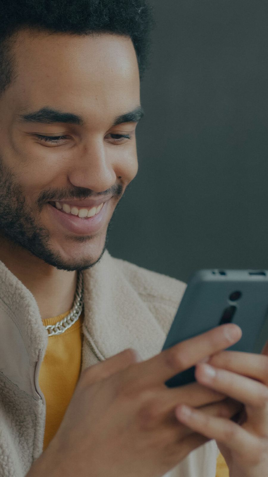 A trader smiling at a trade on his phone