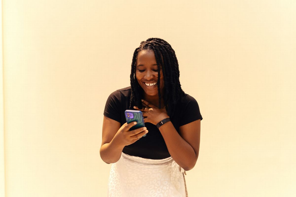 A woman smiling at her phone